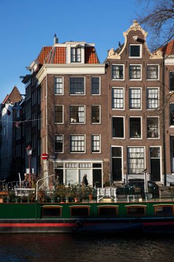 Amsterdam kanal kemerinde sokak hayatı ve mobilyalarla tipik Hollanda mimari binaları