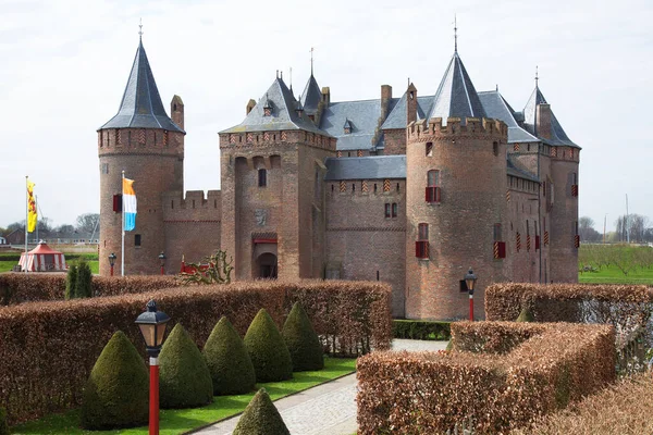 Kırpılmış kayın çitleriyle resmi bahçeli antik bir kale.