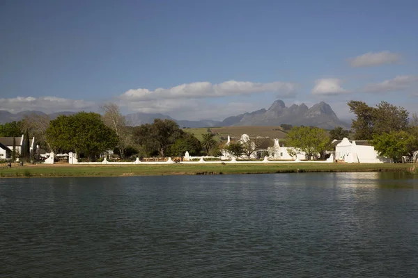 Binaları ve nehirden uzak dağları olan kıyı manzarası