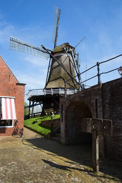 レンガの石の標準とパターン舗装上の典型的なオランダの古い製粉所は 風力エネルギーを生成するために変換されます — ストック写真