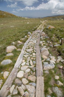 Bulutlu gökyüzünün altındaki dağlık manzaranın görüntüsü