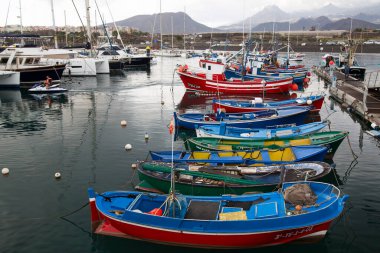Limanda demirli tekneler ve arka planda dağlar.