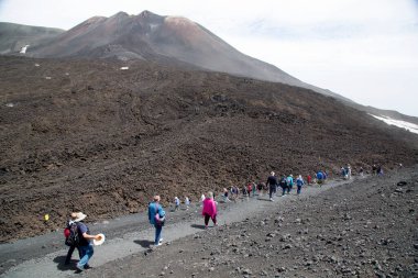 Bir grup turist güzel bir dağ manzarasında yürüyor.