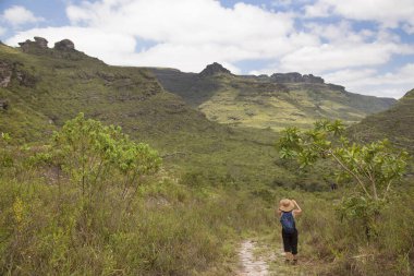 Dağlık arazide şapka takan kadın yürüyüşçünün dikiz görüntüsü