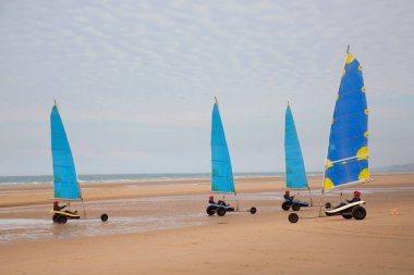 Plajda bir blokart, arazi ya da kum yelkenli araba ya da yük arabasıyla, rüzgarla çalışan üç tekerlekli ve yelkenli bir kara aracı ile yapılan bir yarışma.