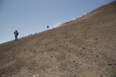 Volkanik tepelerde yürüyen bir grup insan