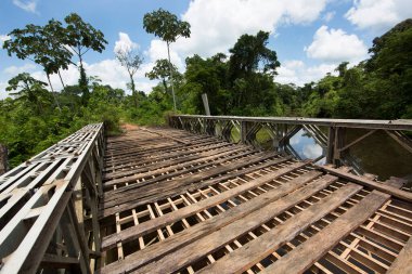 Tipik Amazon kırsal kesiminde orman köprüsü nehir geçidi çelik, perçin ve ahşap tahtalarla kaplı.