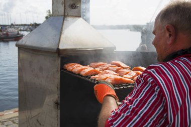 Barajda balık pişiren bir adamın görüntüsü.