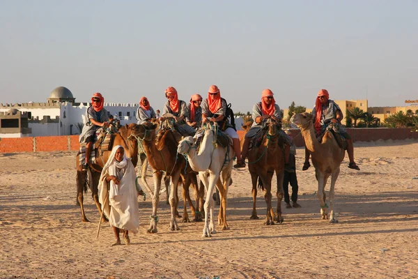 Θέα Των Ανθρώπων Που Ιππεύουν Καμήλες Στην Έρημο — Φωτογραφία Αρχείου