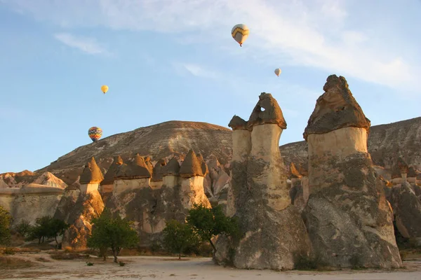 Turistlerle dolu sıcak hava balonları ulusal parkın üzerindeki volkanik bir arazide bunaltıcı manzaranın keyfini çıkarıyor.
