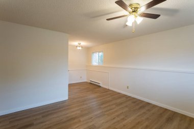 Beyaz duvarları ve yeni sert ahşap kaplama döşemeleri olan yenilenmiş apartman dairesi kiralama ünitesi..