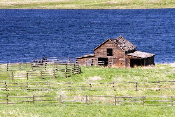 Kamloops, British Columbia, Kanada yakınlarındaki Ayrılık Gölü 'nde terk edilmiş eski bir kır evi ahırı..