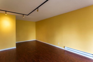 Yeni, modern bir apartman dairesinin boş oturma odası manzarası içi boş sarı duvarlarla dolu..