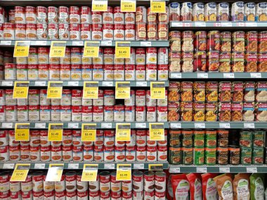 British Columbia, Kanada - 12 Eylül 2025: Bir süpermarketin gıda reyonunda farklı türde konserve çorbalarla dolu raflar gösteriliyor. Satış fiyatları belirgin olarak belirlendi.