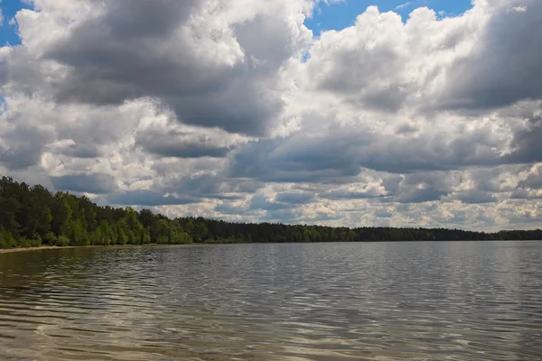 Festői tó és erdő. Fehér felhők, a különböző formák záródnak, kék ég és a nap (Pisochne ozero, Ukrajna) — Stock Fotó