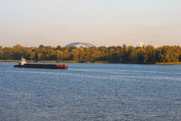 通过水路运送货物 拖船拖着一艘空驳船 基辅风景秀丽的秋景 自然景观 第聂伯河和Trukhaniv岛与多云的天空相对照 乌克兰基辅 — 图库照片