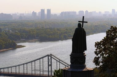 Yaya köprüsü ve Büyük Vladimir Anıtı ile Dnipro Nehri 'nin manzarası. Arka planda sisli modern gökdelenler. Aziz Vladimir Tepesi, Kyiv, Ukrayna.