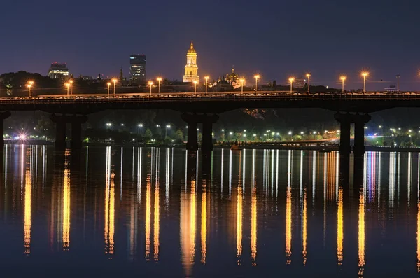 位于第聂伯河上的帕顿桥的夜景 灯笼反射在水面上的光 基辅佩赫尔斯克拉瓦拉灯塔的照明塔 水中反射的城市灯光 — 图库照片