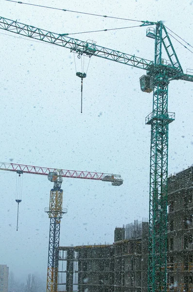 Due Gru Torre Vicino Edificio Incompiuto Durante Caduta Della Neve — Foto Stock