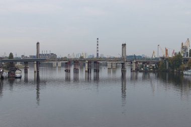 Sonbahar manzaralı sabah manzarası. Rybalskyi Adası 'na giden eski bir köprüyü sökme işlemi (veya Peninsula). Köprü suya yansıdı. Arka plandaki sanayi binası. Kyiv, Ukrayna.