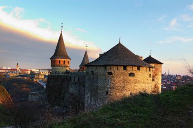 Kış günbatımında Kamianets-Podilskyi kentindeki antik taş kalenin manzara fotoğrafı. Panoramik dramatik günbatımı gökyüzü. Ünlü turistik yer ve romantik seyahat merkezi. Ukrayna..