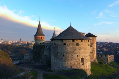 Kış günbatımında Kamianets-Podilskyi kentindeki antik taş kalenin manzara fotoğrafı. Panoramik dramatik günbatımı gökyüzü. Ünlü turistik yer ve romantik seyahat merkezi. Ukrayna..