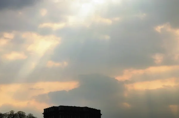 有云彩 光芒和其他大气效应的日落天空 日落时 金色的云彩呈现在戏剧性的光芒中 建筑物的黑色轮廓和照片底部的树木 乌克兰基辅 — 图库照片