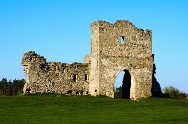 Antik Krements şatosunun harabelerinin detaylı görüntüsü. Mavi gökyüzüne karşı savunma duvarı ve kale kulesinin bir parçası. Arka planda ağaçlar var. Manzaralı bahar günbatımı. Kremenetler, Ternopil ili, Ukrayna.