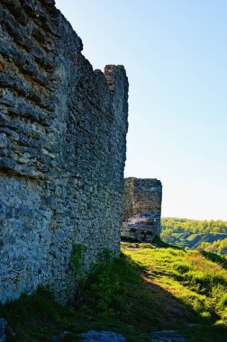 Bona Hill 'deki antik Krements şatosunun taş duvarını koruyan harabelerin yakın görüntüsü. Mavi gökyüzü arka planı. Manzaralı bahar günbatımı. Seyahat ve turizm konsepti. Kremenetler, Ternopil ili, Ukrayna.