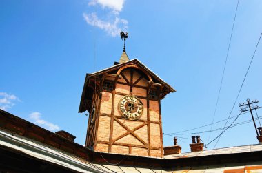 Scenic landscape view of ancient wooden townhall with vintage clock against cloudy sky. Chortkiv, Ukraine.