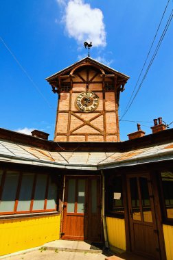 Wide angle landscape view of ancient wooden townhall with vintage clock against cloudy sky. Chortkiv, Ukraine.