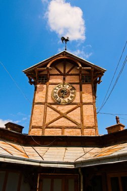 Detailed view of ancient wooden townhall with vintage clock against cloudy sky. Famous touristic place and romantic travel destination. Popular tourist destination in Chortkiv, Ukraine.