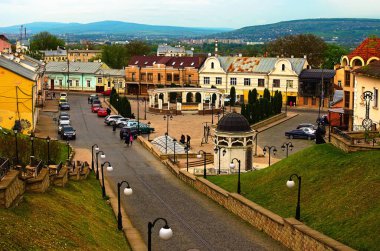 Chernivtsi, Ukrayna-13 Mayıs 2021: Türk kuyusu ile Aziz Maria antik meydanının manzarası. Arka planda mavi gökyüzüne karşı resim gibi bir sıradağ. Seyahat ve turizm kavramı.