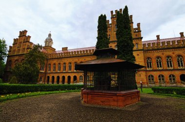 Chernivtsi Üniversitesi 'nin arka bahçesi ve klasik kuyusu olan ortaçağ binasının klasik geniş açılı manzarası. UNESCO Dünya Mirası Alanı. Seyahat ve turizm kavramı.