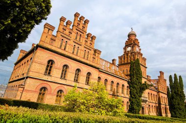 Chernivtsi Üniversitesi 'nde saat kulesi ve iç bahçesi olan ortaçağ kahverengi tuğla binasının klasik geniş açılı manzarası. UNESCO Dünya Mirası Alanı. Seyahat ve turizm kavramı.