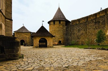 Ortaçağ şatosunda antik taş binalar olan avlu manzarası. Arka planda kule olan yüksek taş duvar. Ünlü turistik yer ve romantik seyahat merkezi..