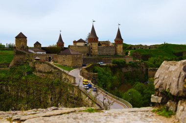 Mavi gökyüzüne karşı eski köprüsü olan antik kalenin resimli bahar manzarası. Arka planda yeşil tepeler var. Ünlü turistik yer ve romantik seyahat merkezi..