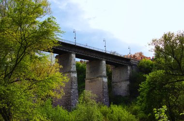 Yüksek katlı taş destekli köprünün ayrıntılı görüntüsü. Nehir boyunca taş destekli köprü. Bulutlu bir arka plan. Smotrytsky Kanyonu üzerindeki Novoplanovsky köprüsünün manzara görüntüsü.