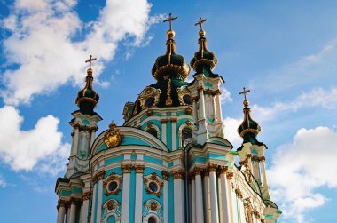 Yakın plan, eski Saint Andrew Kilisesi 'ne karşı beyaz bulutlu mavi gökyüzü. Yaz güneşli bir gün. İki ziyaretçi kiliseye giden merdivenleri tırmandı..