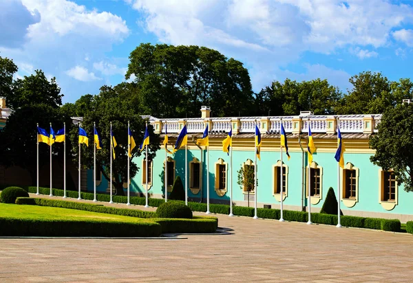 風になびくウクライナのフラグを持つ旗竿の行 背景にはマリリンスキー宮殿の右翼 美しい夏の春の日 — ストック写真