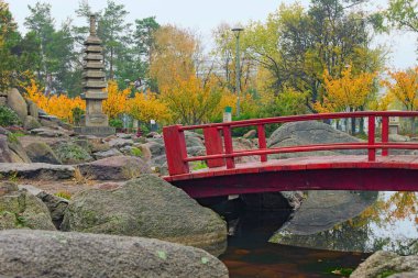 Kyiv 'deki Kyoto Parkı' nın içindeki Japon Bahçesi 'ndeki kırmızı ahşap köprünün muhteşem sonbahar manzarası. Arka planda sonbahar renkleri. Japonya 'nın Kyiv, Ukrayna' daki resmi bir bölümü. 