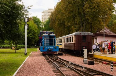 Kyiv, Ukrayna-22 Ağustos 2021: Dar açı lokomotifi TU7A 'nın ayrıntılı görüntüsü. Arka planda birkaç araba var. Syretsky Park 'taki Kyiv Çocuk Demiryolu. Yolcular biniş için bekliyor. Yaz günü.