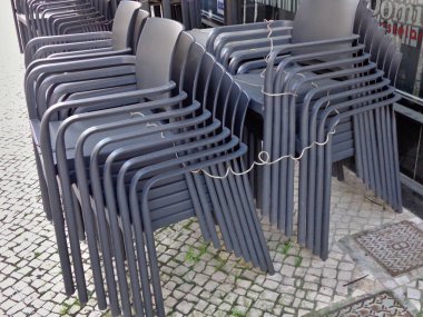 Gestapelte Stuehle bei den Bars und Cafes waeherand des Covid 19 Lockdown
