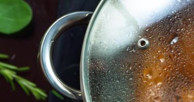 Kapalı bir kapağın altında kaynar suda kaynatılmış sosisler.