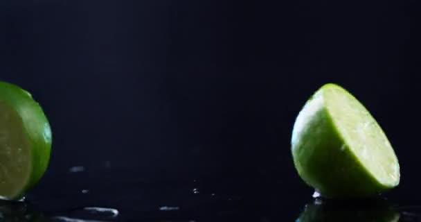 Cut lime falls on a wet surface and falls into two parts — Stock Video