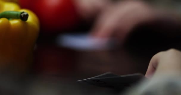 La mano levanta las cartas contra el fondo de las verduras. tomates — Vídeo de stock