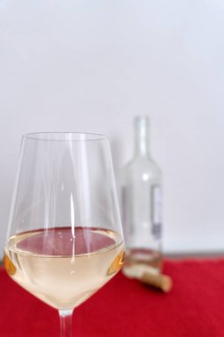 Kırmızı masa örtüsü ve beyaz arka ekranda arka planda bir şişe beyaz şarap. Yüksek kalite fotoğraf