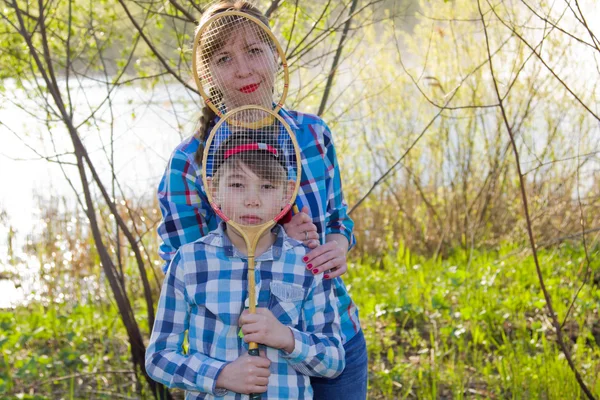Мать и сын с бадминтонной ракеткой — стоковое фото