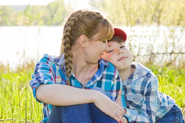 Mère et fils assis sur l'herbe — Photo