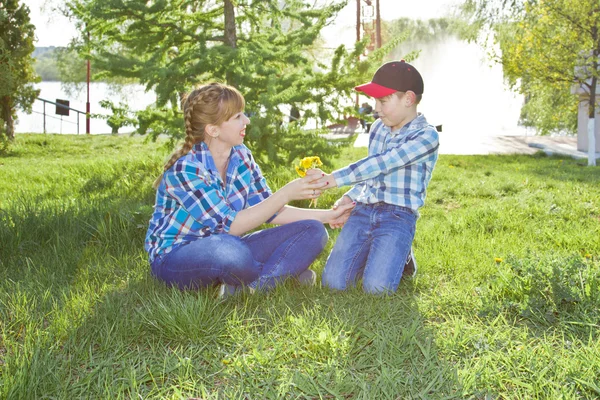 Mère et fils assis sur l'herbe — Photo